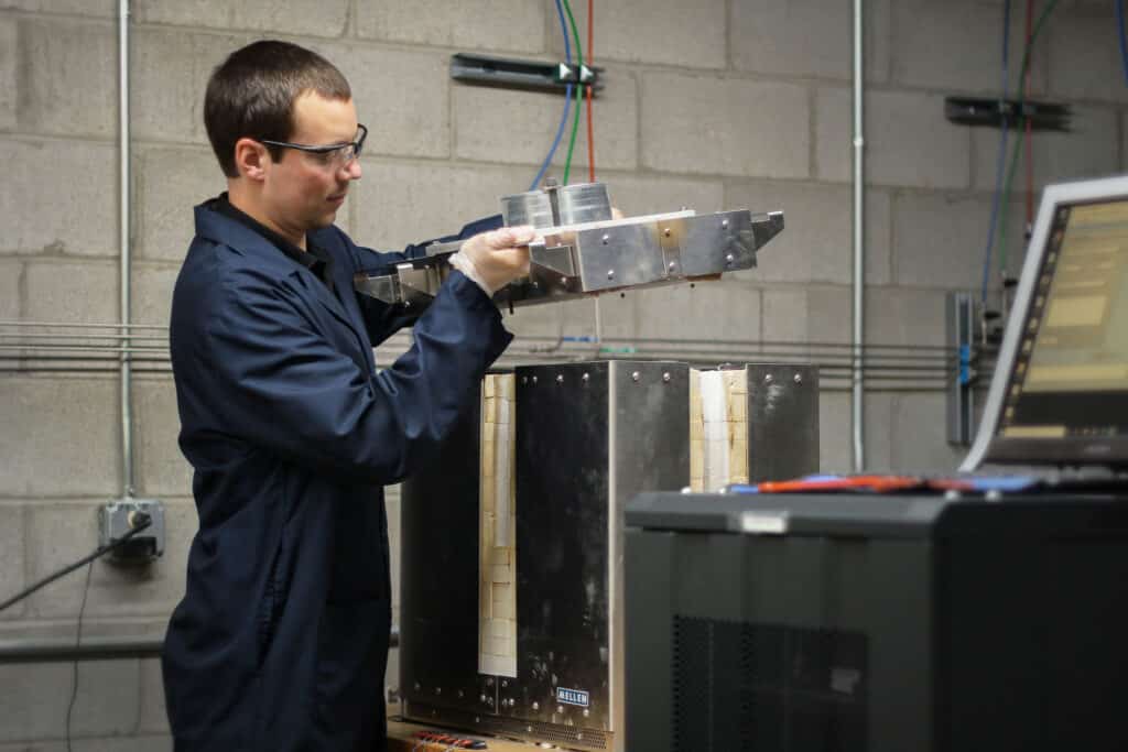 Technician loading a high-temperature furnace for advanced material development and testing.