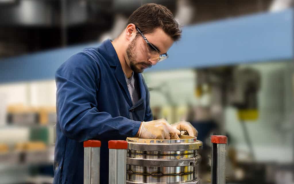 Technician applying a custom washcoat slurry to a structured metallic substrate for advanced catalyst development.