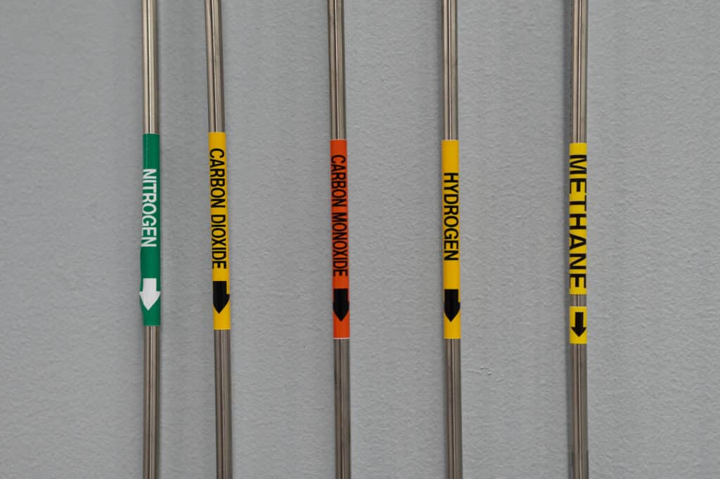 Specialized laboratory gas delivery pipes labeled for nitrogen, carbon dioxide, carbon monoxide, hydrogen, and methane for clean energy material testing.